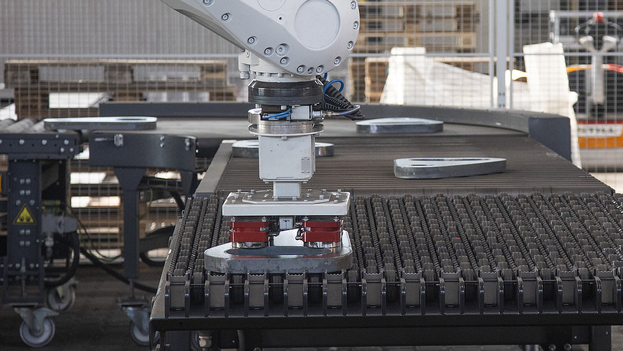 Handling Roboter legt Blechteil ab
